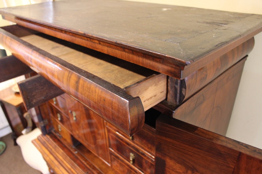 An 18th-century walnut cabinet on stand featuring double doors with book-matched veneer panels, a lower drawer base, and six barley-twist legs joined by a wavy stretcher. View VIII