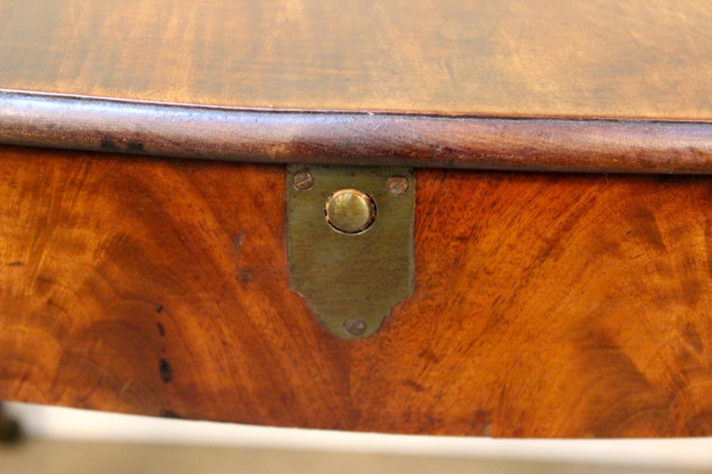A Georgian mahogany kidney-shaped writing desk featuring tapered legs, brass castors, and a central drawer with brass handles. View VIII