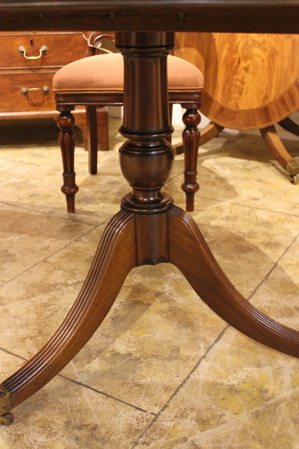A 19th-century mahogany D-end extending dining table supported on twin turned pedestals with reeded splayed legs and brass castors. View IV