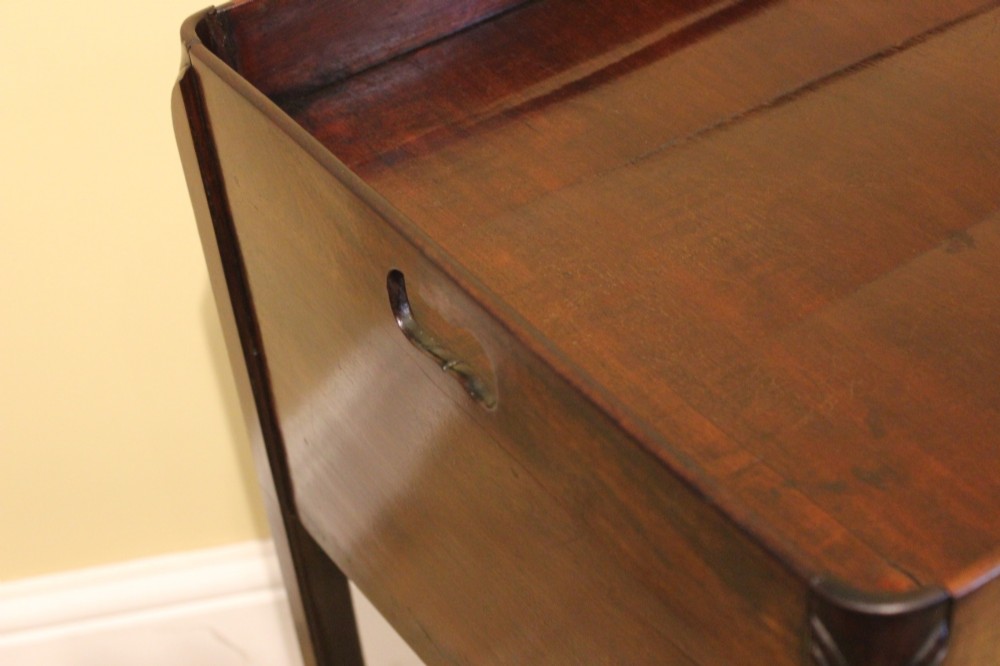 An antique Georgian mahogany bedside table featuring a tray top with cut-out hand-holds, double cupboard doors, a brass pull handle, and straight square legs. View VI