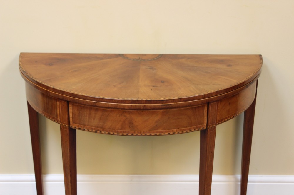 A 19th-century mahogany and fruitwood demi-lune card table featuring fan veneer inlays on the folding top and four tapered legs. View III