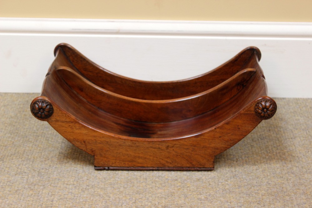 A crescent-shaped Georgian mahogany cheese coaster with carved floral rosettes on the scrolled terminals.