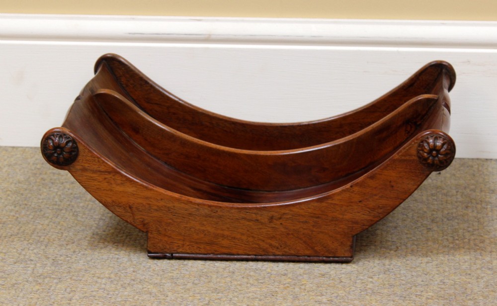 A crescent-shaped Georgian mahogany cheese coaster with carved floral rosettes on the scrolled terminals. View II