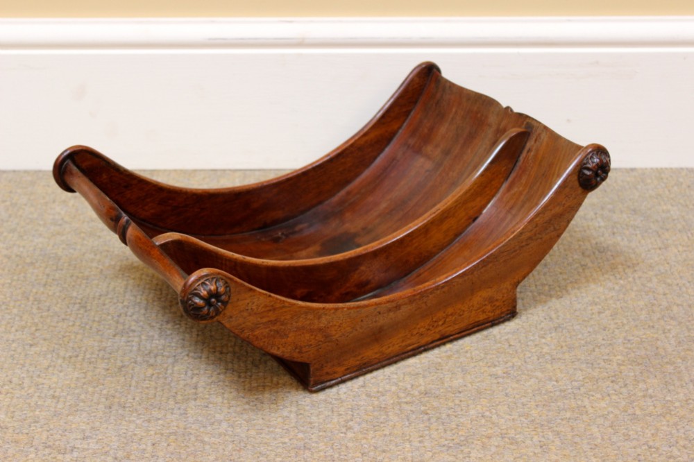 A crescent-shaped Georgian mahogany cheese coaster with carved floral rosettes on the scrolled terminals. View IV