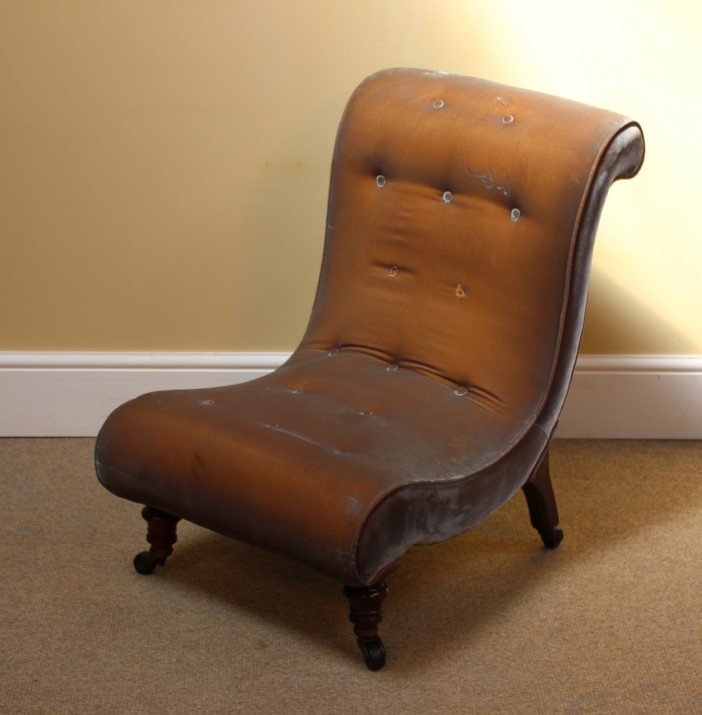 A 19th-century low-seated armless slipper chair upholstered in bronze brown fabric with button tufting on turned walnut legs with castors. View II