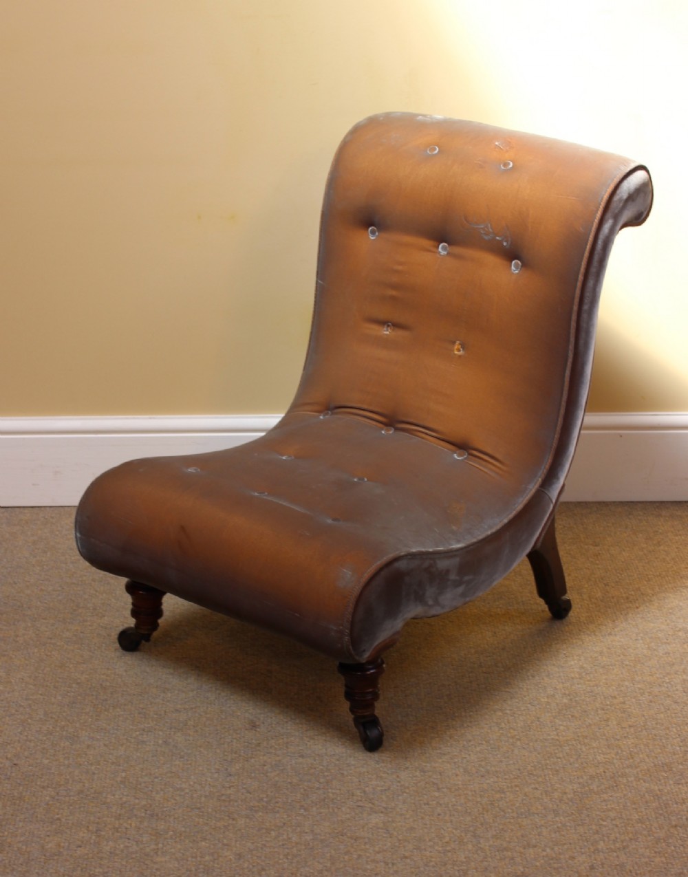 A 19th-century low-seated armless slipper chair upholstered in bronze brown fabric with button tufting on turned walnut legs with castors. View III