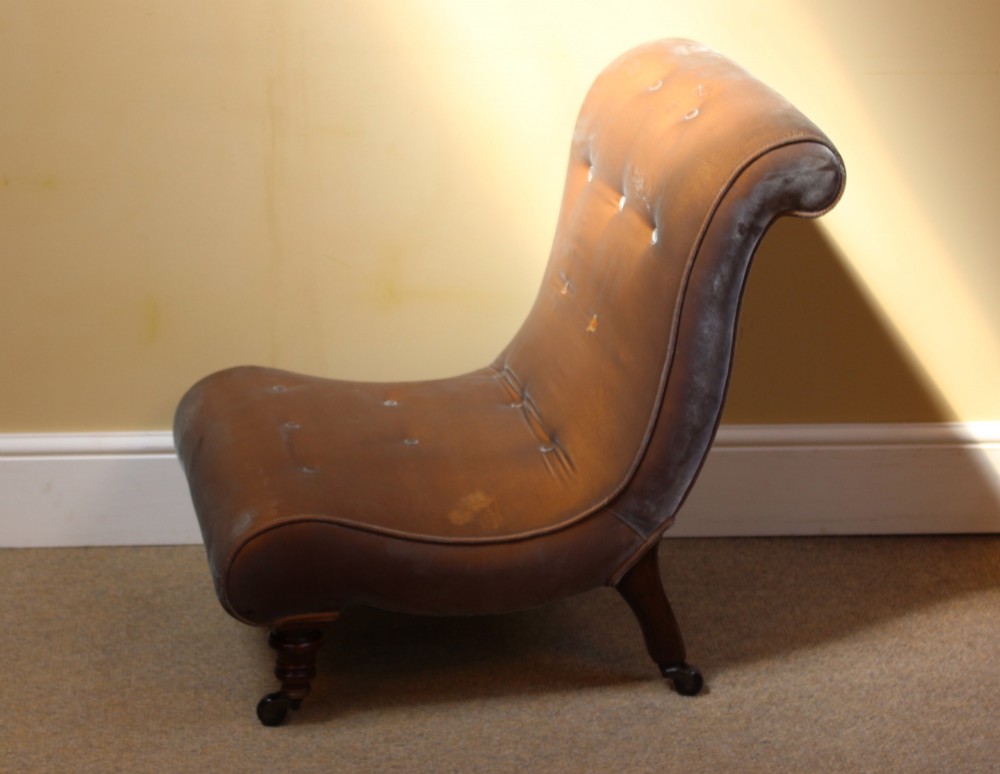 A 19th-century low-seated armless slipper chair upholstered in bronze brown fabric with button tufting on turned walnut legs with castors. View V