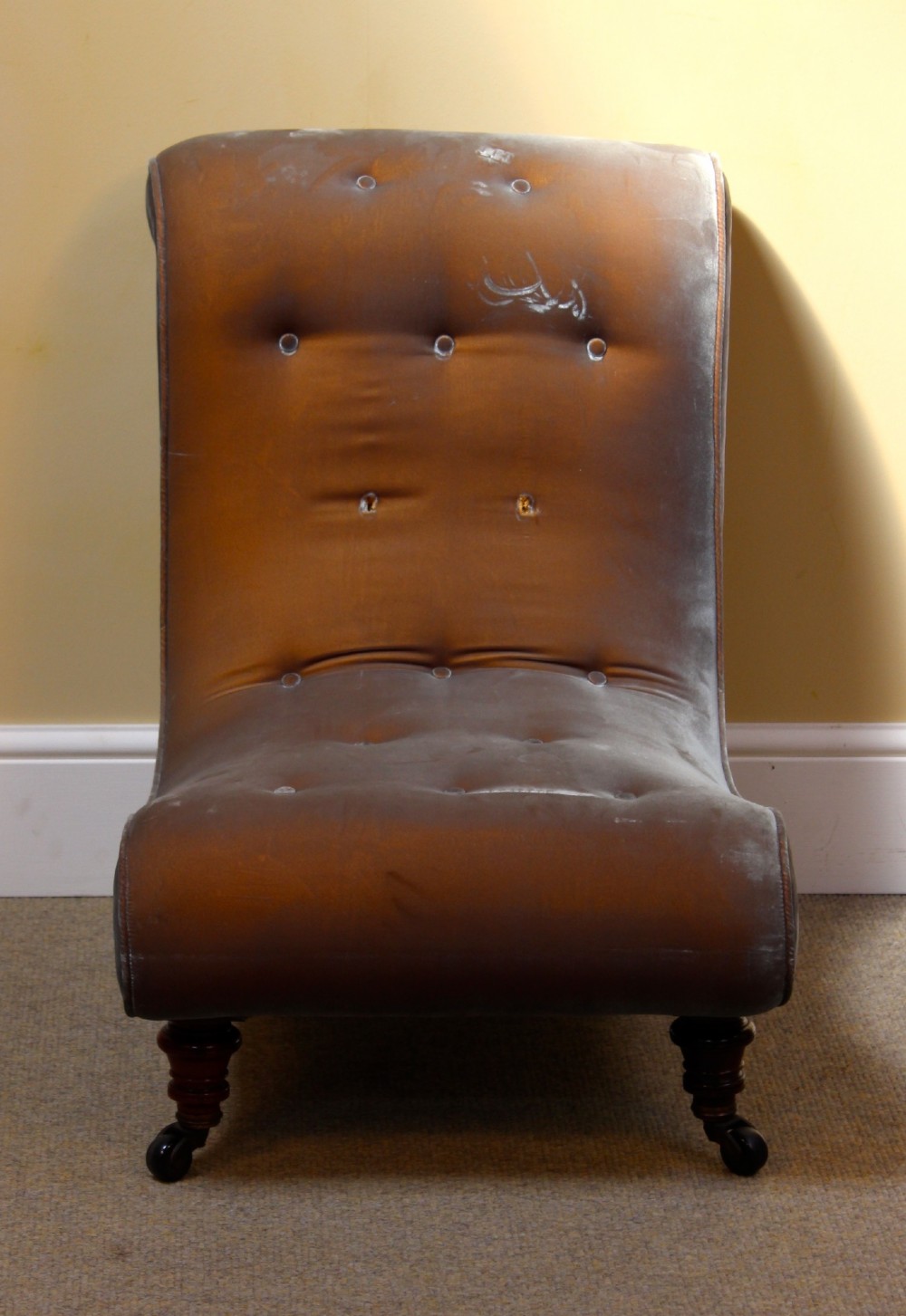 A 19th-century low-seated armless slipper chair upholstered in bronze brown fabric with button tufting on turned walnut legs with castors. View VI