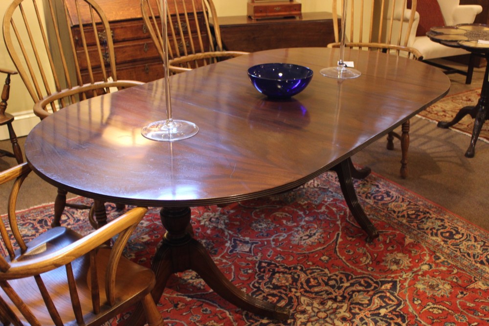 A late nineteenth-century mahogany twin-pillar dining table featuring an oval top supported by two turned pedestals with splayed reeded tripod legs. View III