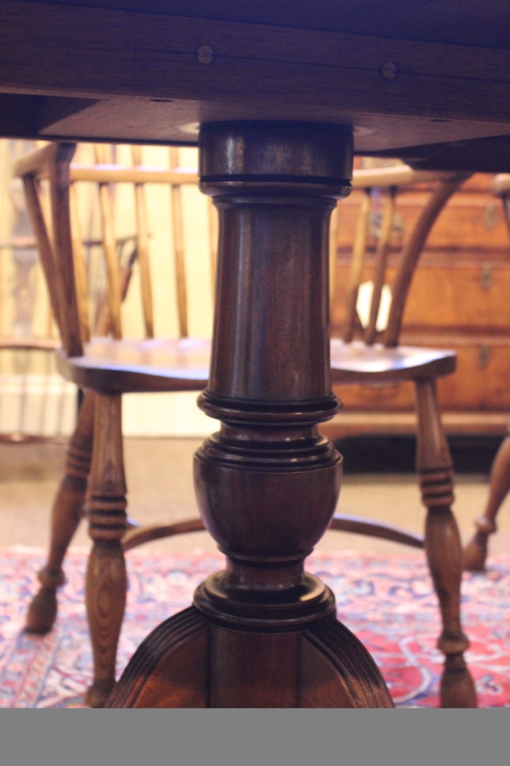 A late nineteenth-century mahogany twin-pillar dining table featuring an oval top supported by two turned pedestals with splayed reeded tripod legs. View IV