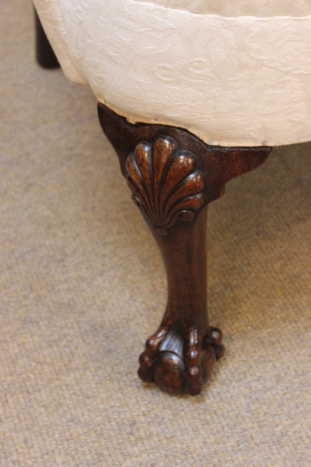 A 19th-century wingback armchair upholstered in cream patterned fabric featuring carved dark walnut cabriole front legs. View VI