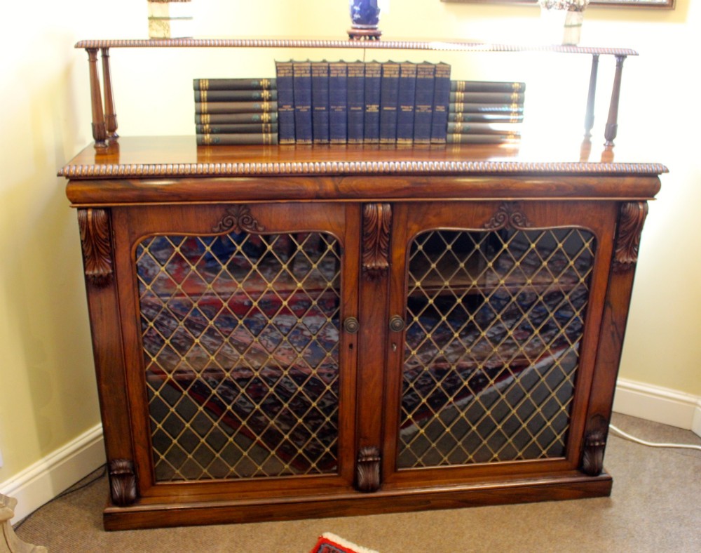 A 19th-century dark rosewood chiffonier cabinet featuring a raised top shelf on turned columns and two doors with brass wire lattice grilles. View II
