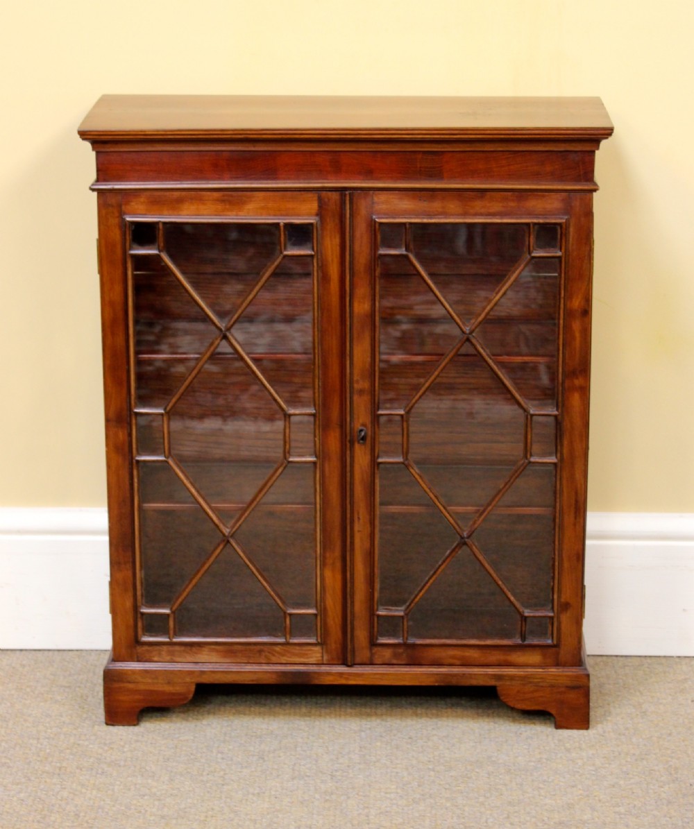 A 19th-century miniature mahogany display cabinet featuring twin astragal glazed doors and bracket feet. View II