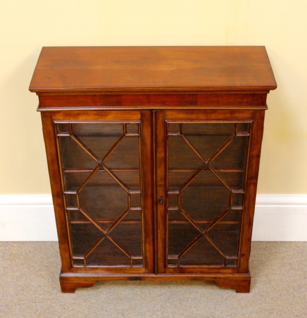 A 19th-century miniature mahogany display cabinet featuring twin astragal glazed doors and bracket feet. View IV