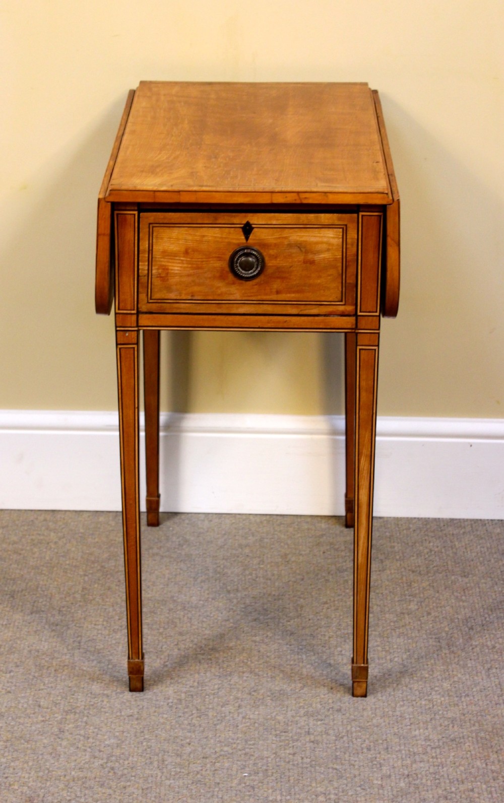 A Regency satinwood drop flap side table featuring inlaid stringing, a single drawer with a brass knob, and square tapered legs. View II