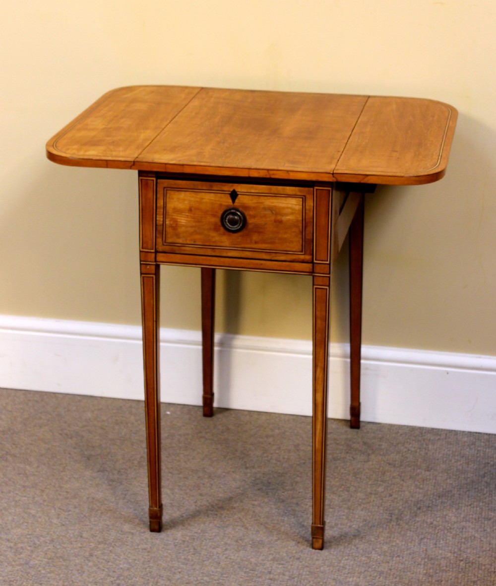 A Regency satinwood drop flap side table featuring inlaid stringing, a single drawer with a brass knob, and square tapered legs. View V