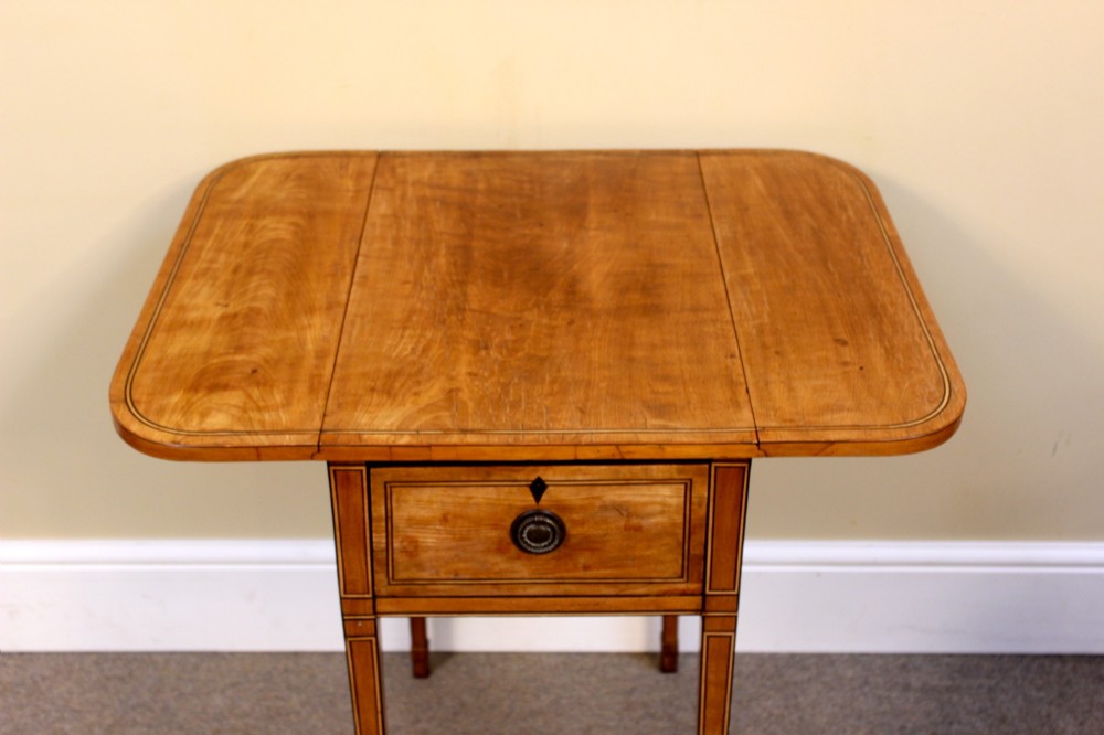 A Regency satinwood drop flap side table featuring inlaid stringing, a single drawer with a brass knob, and square tapered legs. View VII