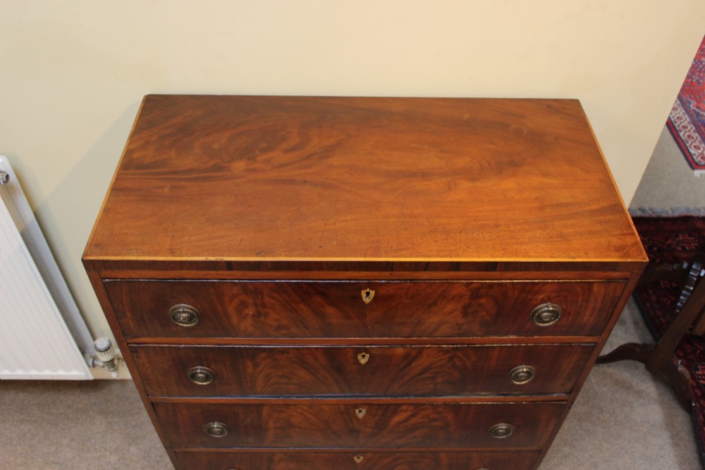 A nineteenth-century mahogany chest of four graduated drawers featuring flame mahogany grain and brass handles. View III
