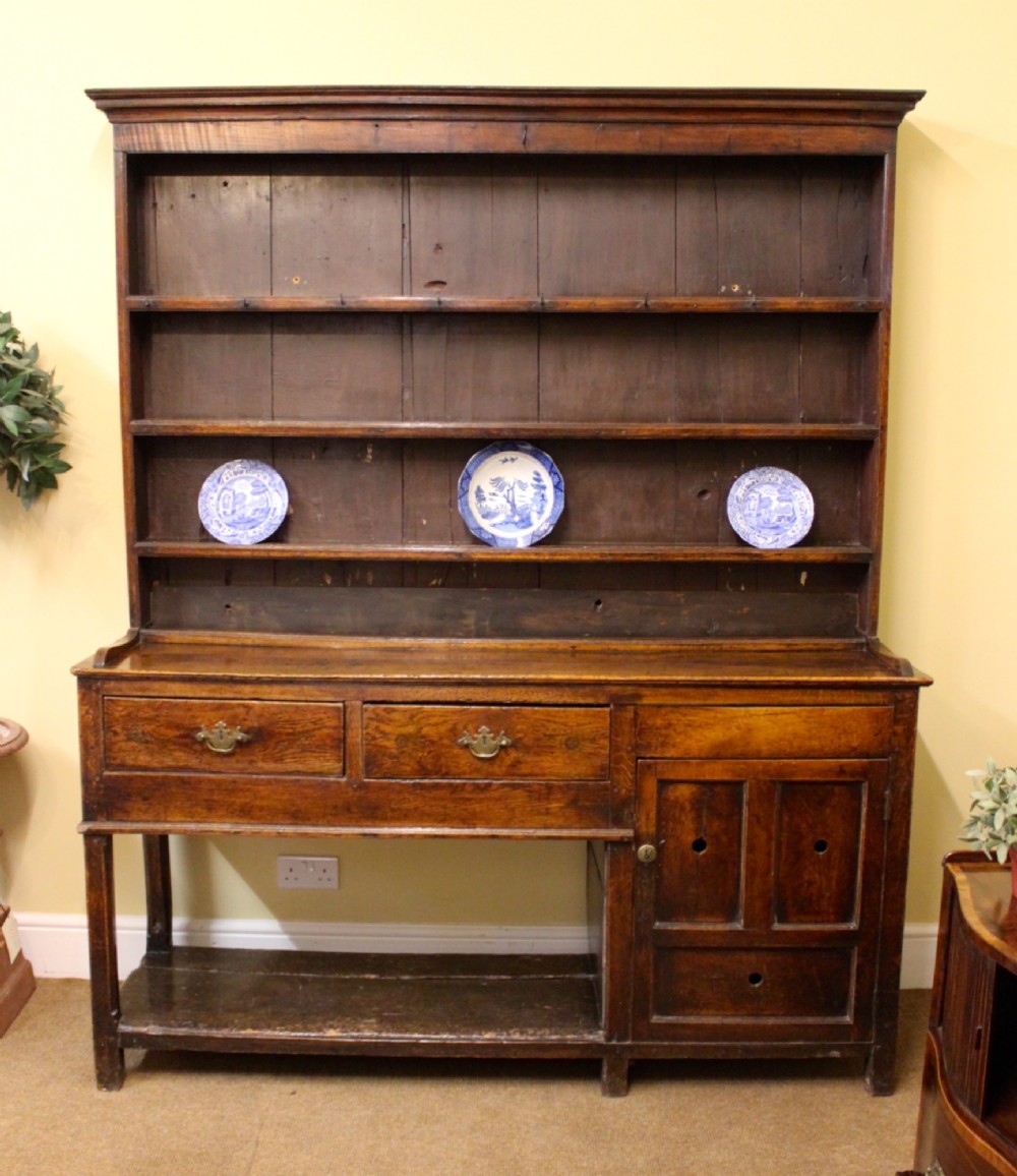 An 18th-century dark oak dresser featuring a multi-tier open plate rack above a drawer and cupboard base with a lower pot board. View II