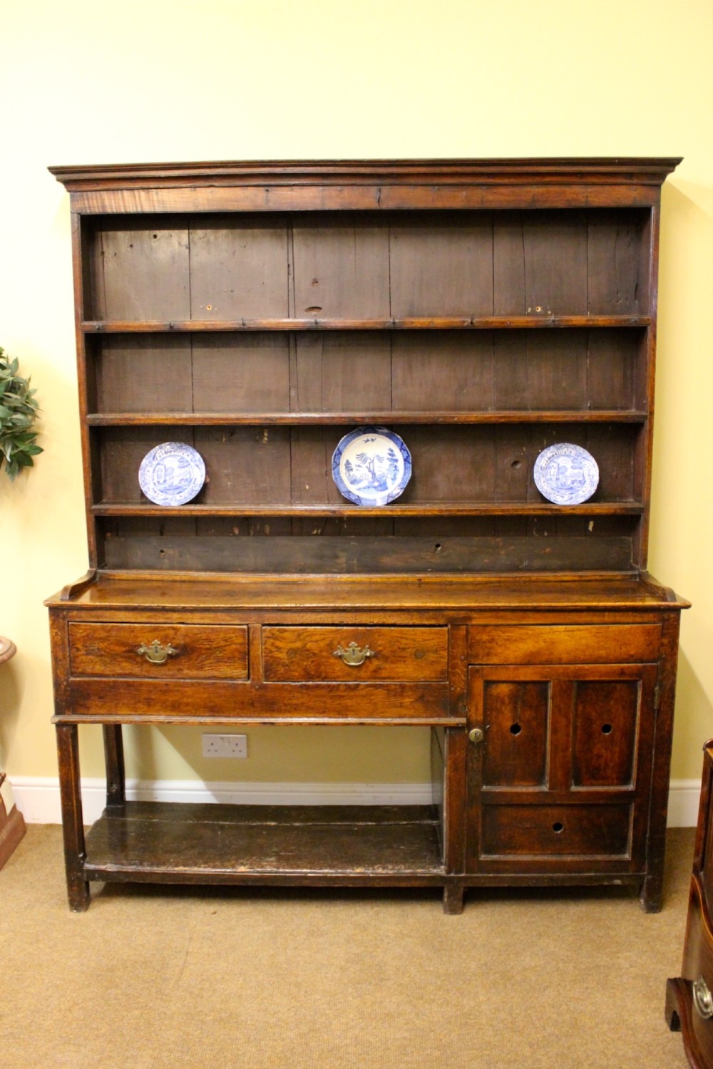 An 18th-century dark oak dresser featuring a multi-tier open plate rack above a drawer and cupboard base with a lower pot board. View III