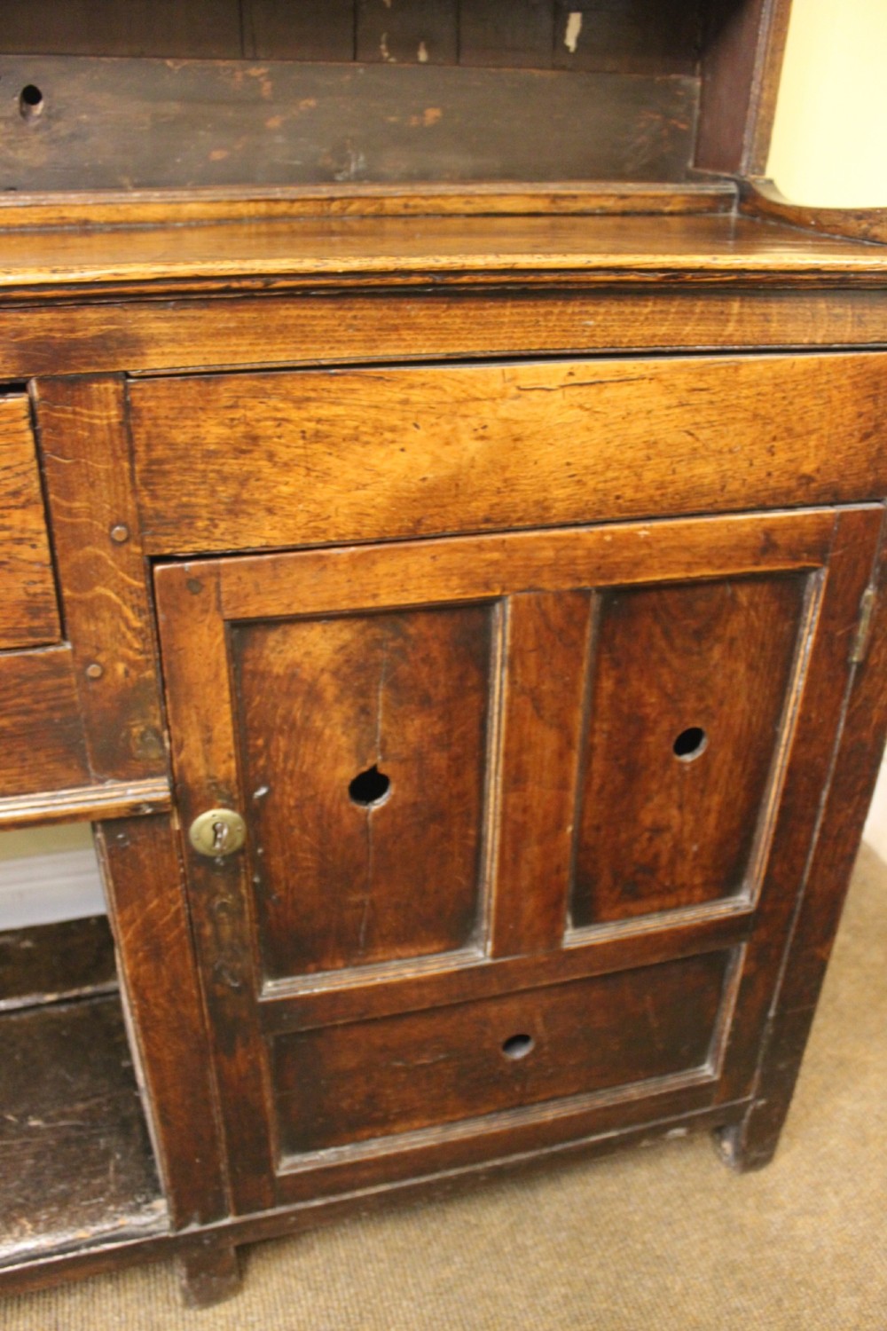An 18th-century dark oak dresser featuring a multi-tier open plate rack above a drawer and cupboard base with a lower pot board. View V