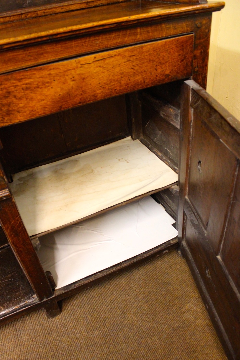 An 18th-century dark oak dresser featuring a multi-tier open plate rack above a drawer and cupboard base with a lower pot board. View VI