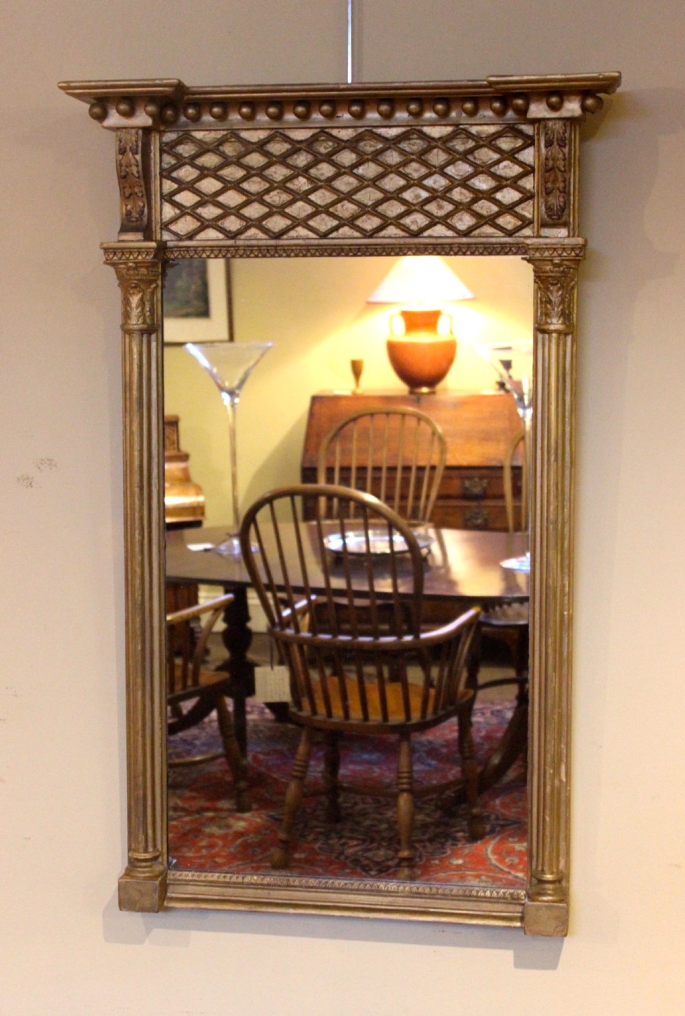 A tall 19th-century giltwood pier mirror featuring fluted side pilasters, a ball-moulded cornice, and a lattice pattern top frieze. View II