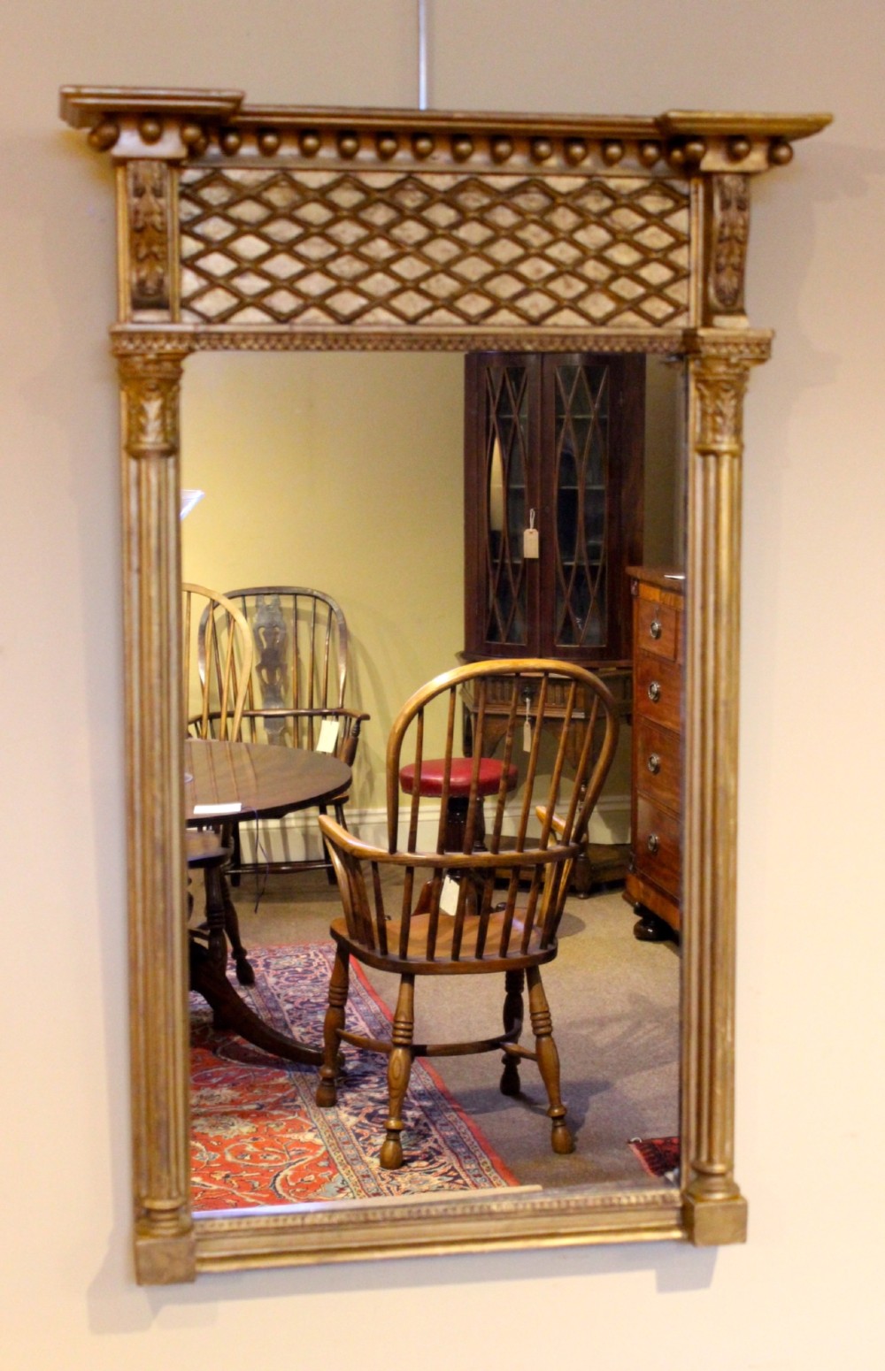 A tall 19th-century giltwood pier mirror featuring fluted side pilasters, a ball-moulded cornice, and a lattice pattern top frieze. View III