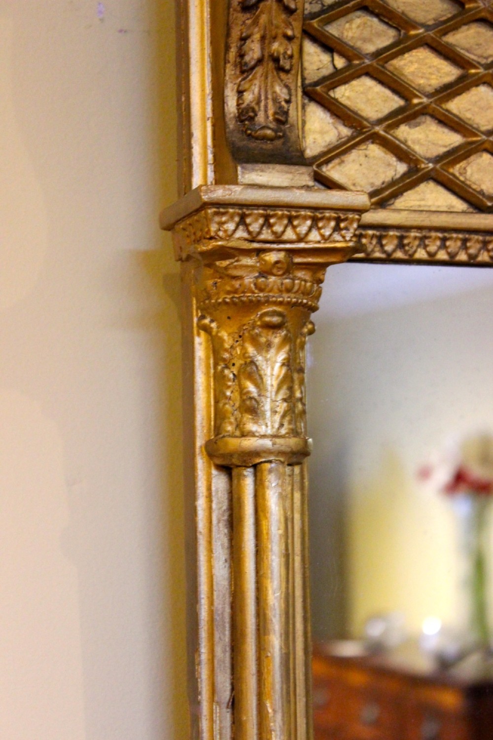 A tall 19th-century giltwood pier mirror featuring fluted side pilasters, a ball-moulded cornice, and a lattice pattern top frieze. View V