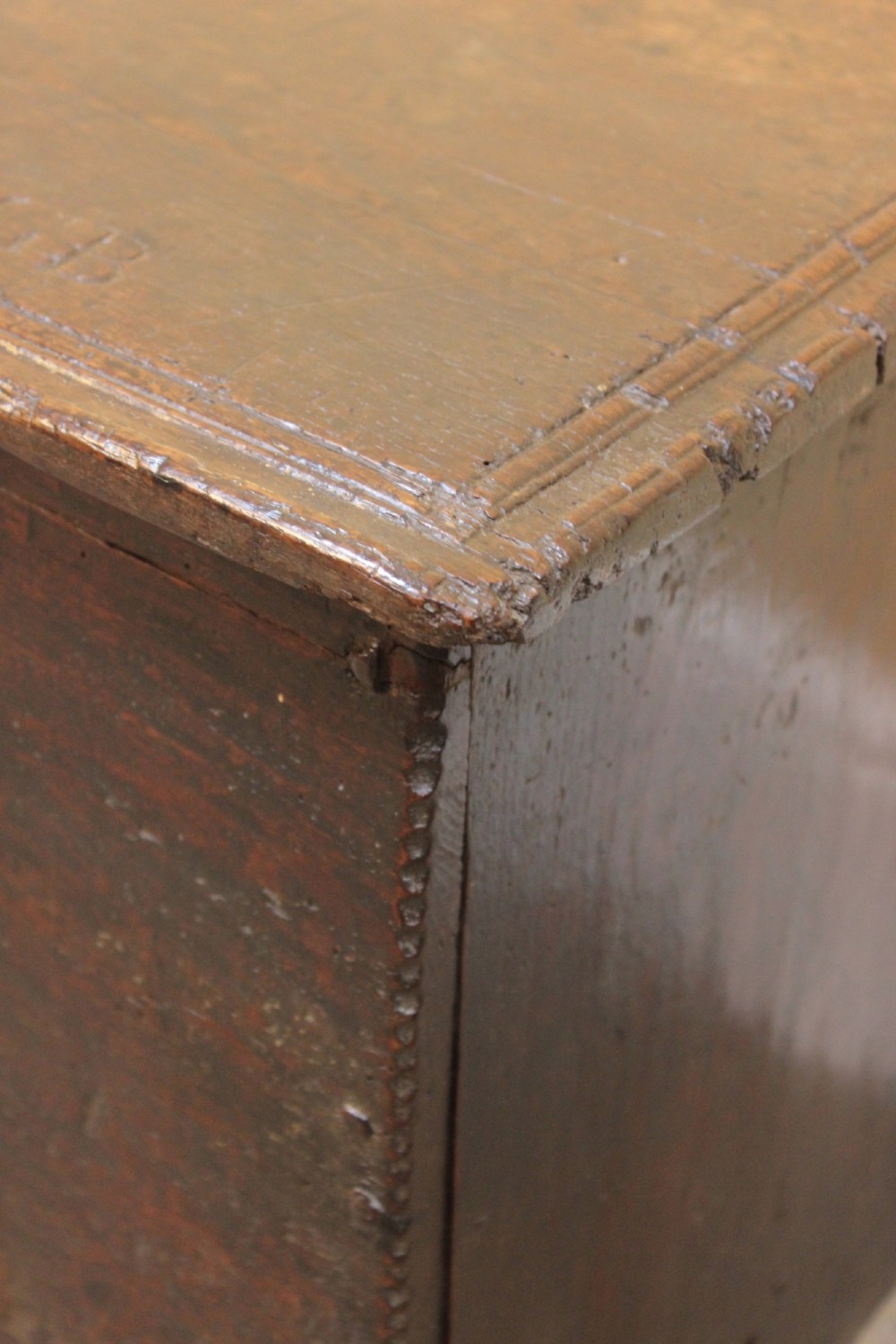 A 17th-century dark oak six-plank coffer featuring a hinged rectangular lid, hand-forged iron lockplate, and slab sides. View IV