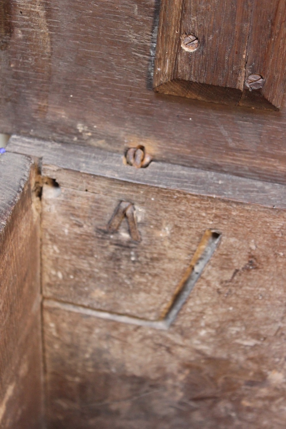 A 17th-century dark oak six-plank coffer featuring a hinged rectangular lid, hand-forged iron lockplate, and slab sides. View VI