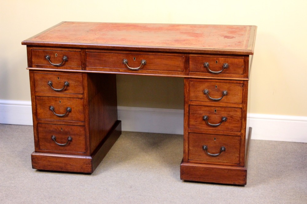 A 19th-century mahogany pedestal desk featuring an inset leather writing top, nine drawers with brass handles, and plinth bases. View II