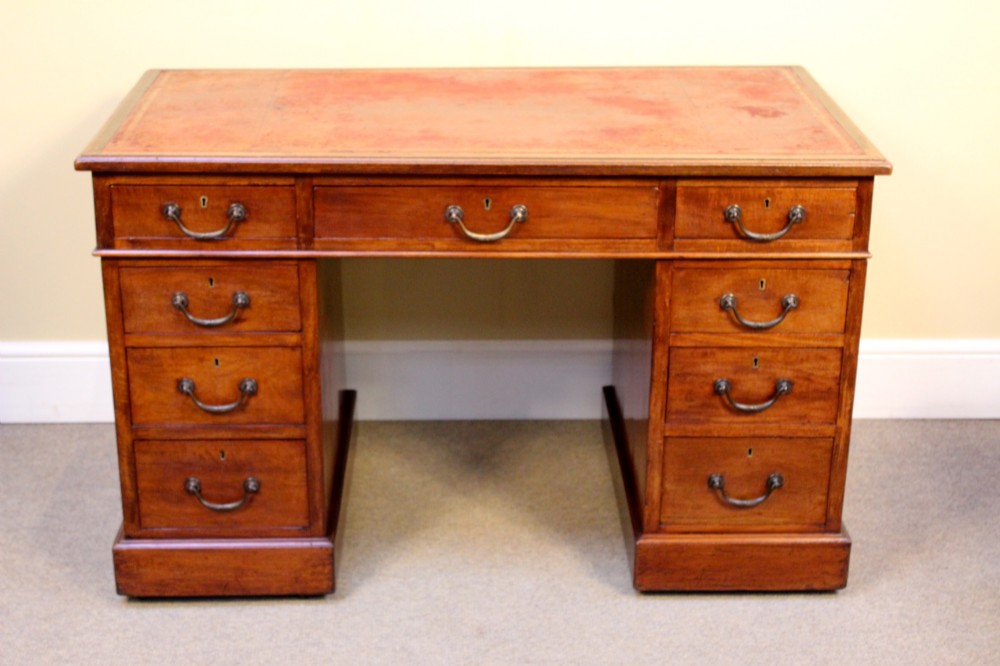 A 19th-century mahogany pedestal desk featuring an inset leather writing top, nine drawers with brass handles, and plinth bases. View III