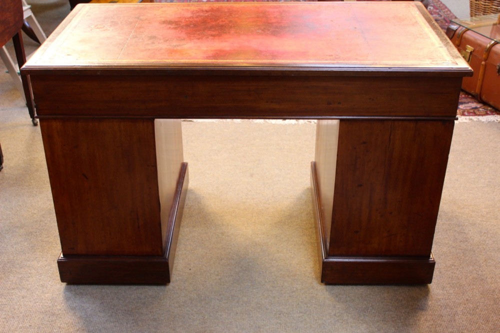 A 19th-century mahogany pedestal desk featuring an inset leather writing top, nine drawers with brass handles, and plinth bases. View VIII