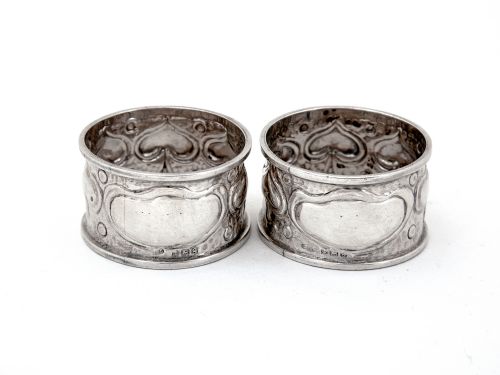 PAIR OF ARTS AND CRAFTS STYLE SILVER NAPKIN RINGS CHASED WITH STYLISED FOLIAGE - ADDITIONAL PHOTO 1