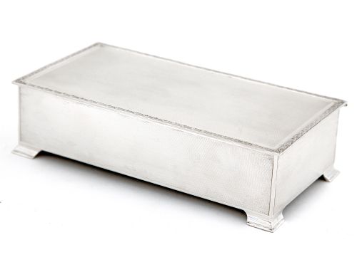 silver table cigar or cigarette box with an engine turned lid and floral scroll borde - CATEGORY: ANTIQUE SILVER - DATED 1930