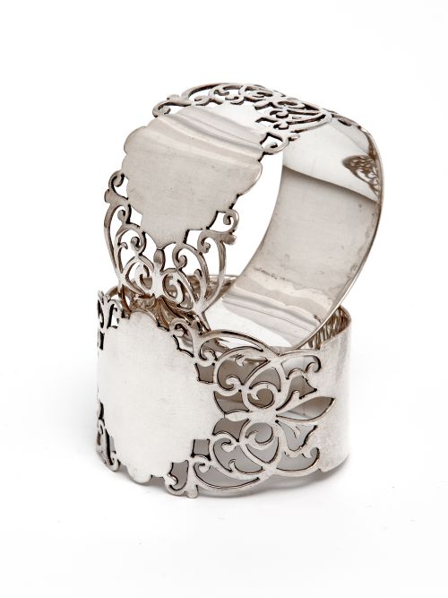 pair of oval silver napkin rings with a pierced scroll body - CATEGORY: ANTIQUE SILVER - DATED 1910