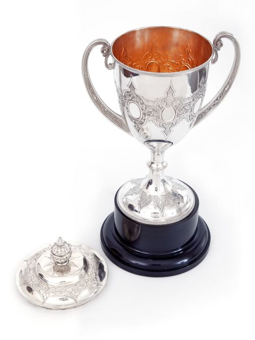 ANTIQUE SILVER PLATED TROPHY WITH TWO CAST SCROLL HANDLES STANDING ON A BLACK PLINTH - ADDITIONAL PHOTO 1