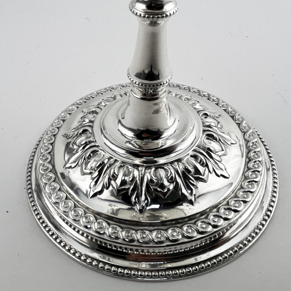 A Victorian silver plated trophy cup featuring ornate scrolled handles, repousse floral engraving, and a circular decorated pedestal foot. View V