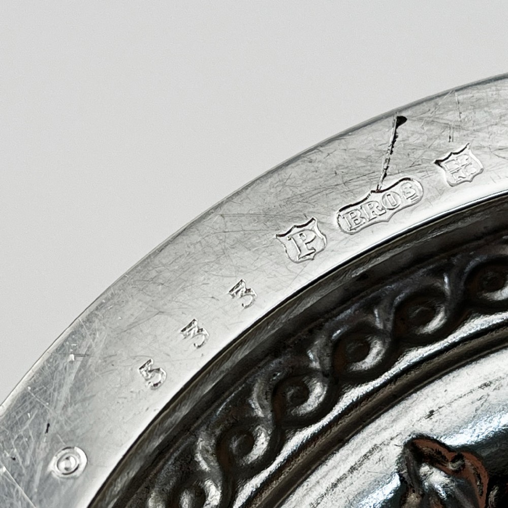 A Victorian silver plated trophy cup featuring ornate scrolled handles, repousse floral engraving, and a circular decorated pedestal foot. View VI