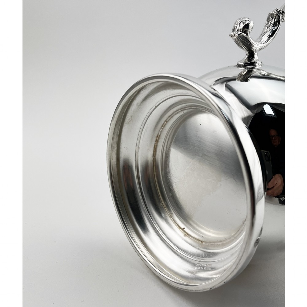An Edwardian silver-plated loving cup featuring a polished bell-shaped body mounted with three ornate cast handles decorated with vine leaf motifs. View V