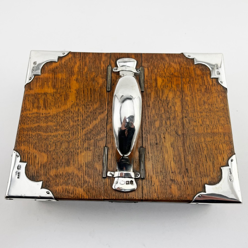 A rectangular oak wood box featuring sterling silver corner mounts and a central silver handle on the lid. View II