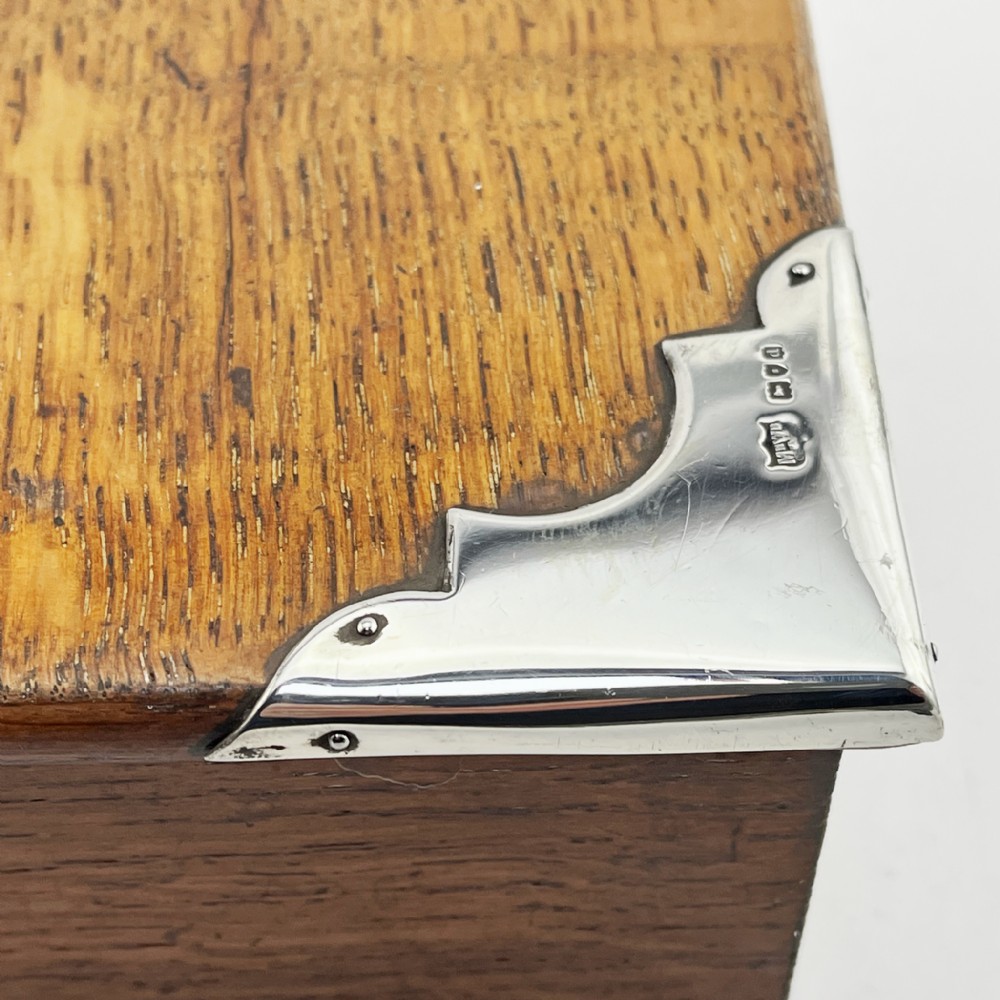 A rectangular oak wood box featuring sterling silver corner mounts and a central silver handle on the lid. View III