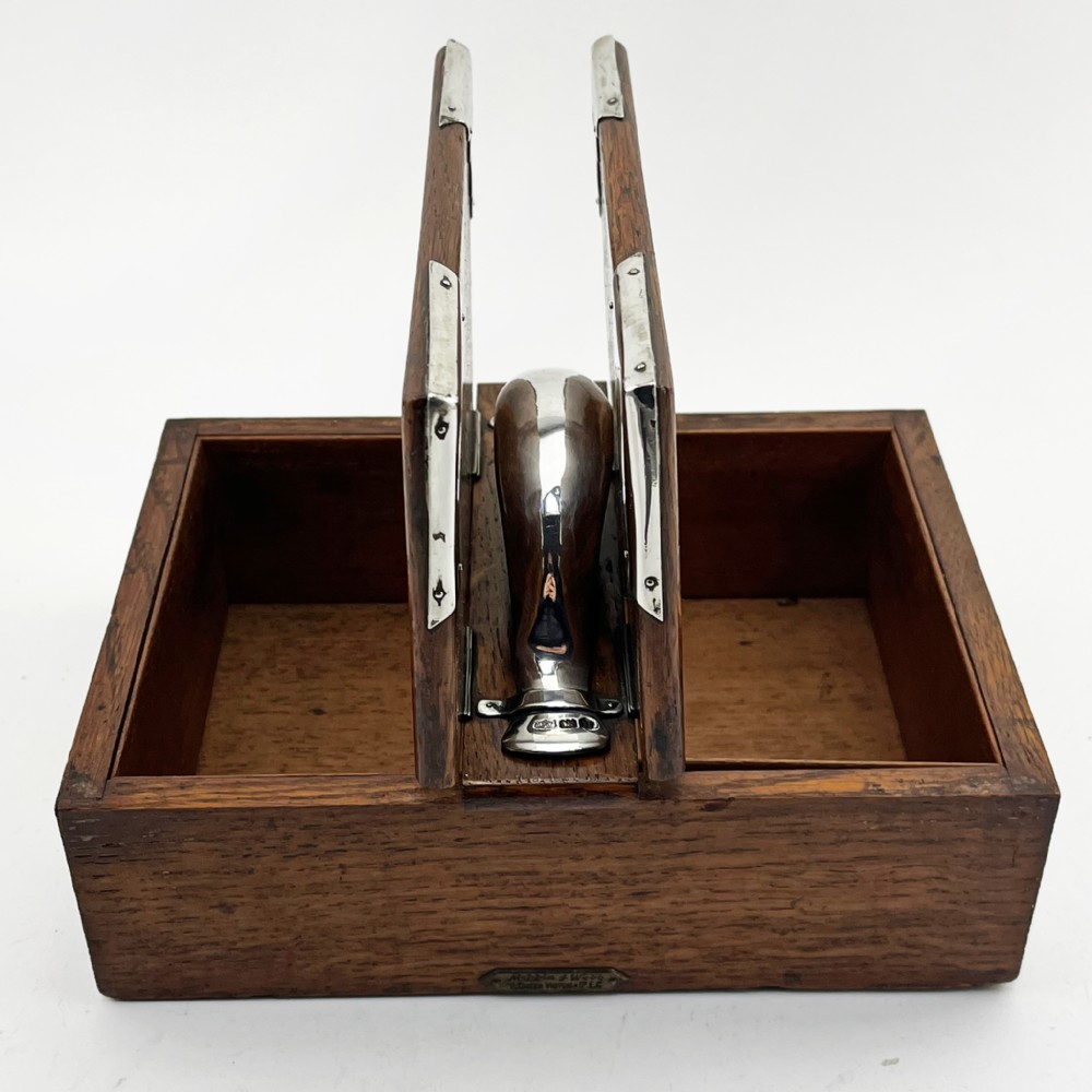 A rectangular oak wood box featuring sterling silver corner mounts and a central silver handle on the lid. View V