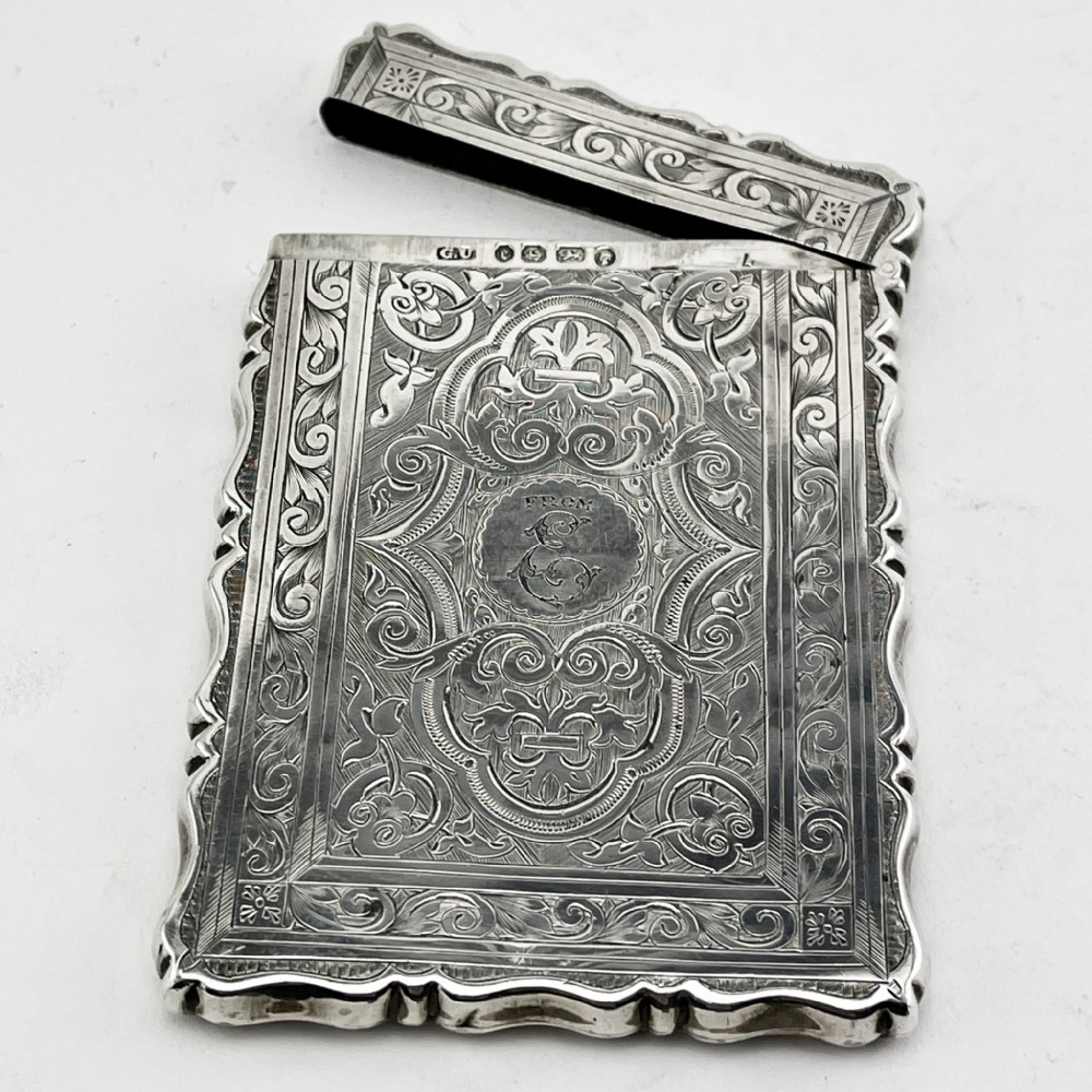Victorian sterling silver card case featuring intricate foliate hand engraving, scalloped edges, and a central monogrammed cartouche. View III
