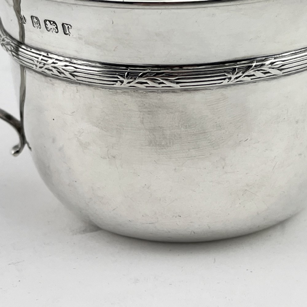 A circular sterling silver porringer featuring two side handles and an engraved decorative band along the rim. View III