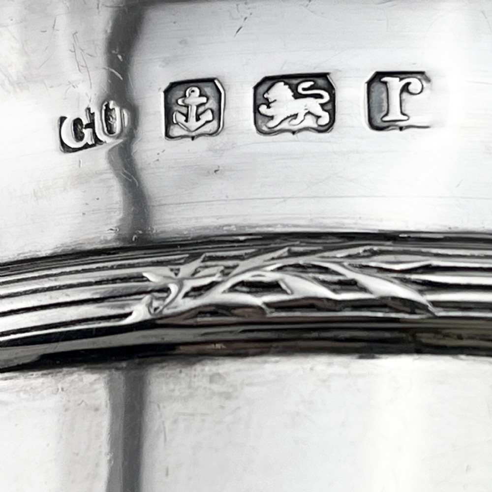 A circular sterling silver porringer featuring two side handles and an engraved decorative band along the rim. View VI