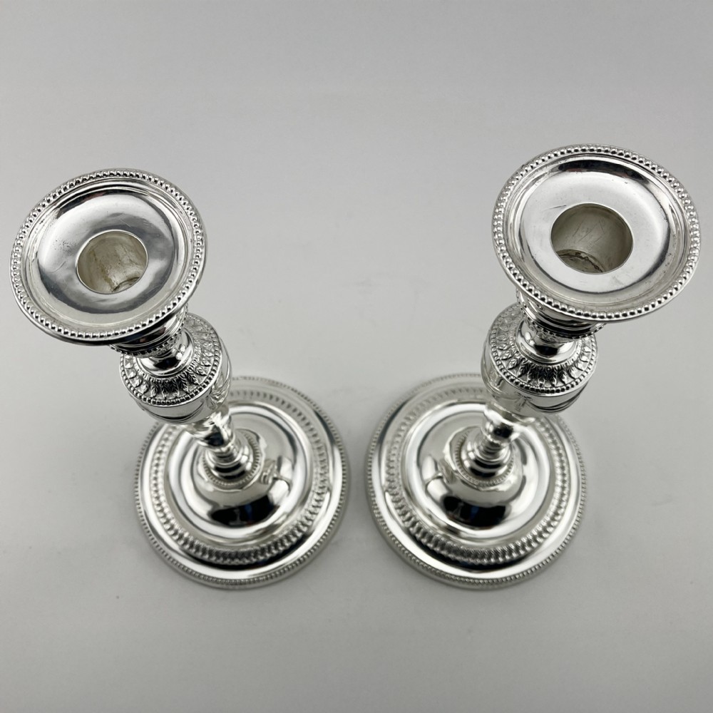 A pair of Victorian silver-plated candlesticks in Georgian Neoclassical style with drapery swags and beaded circular bases. View II