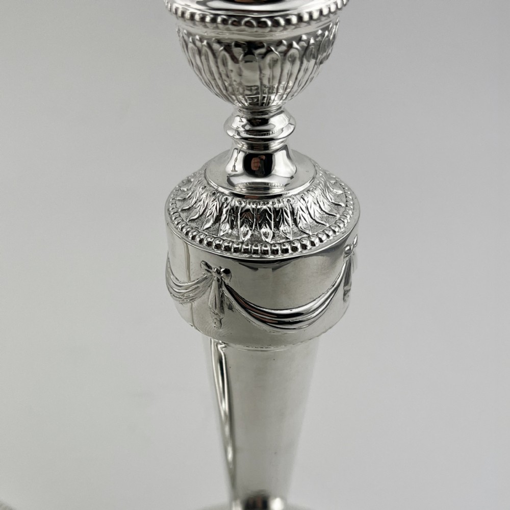 A pair of Victorian silver-plated candlesticks in Georgian Neoclassical style with drapery swags and beaded circular bases. View III