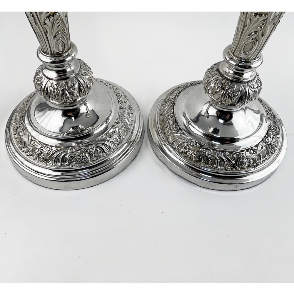A pair of antique silver-plated candlesticks featuring acanthus leaf motifs, knopped stems, and broad circular bases. View II